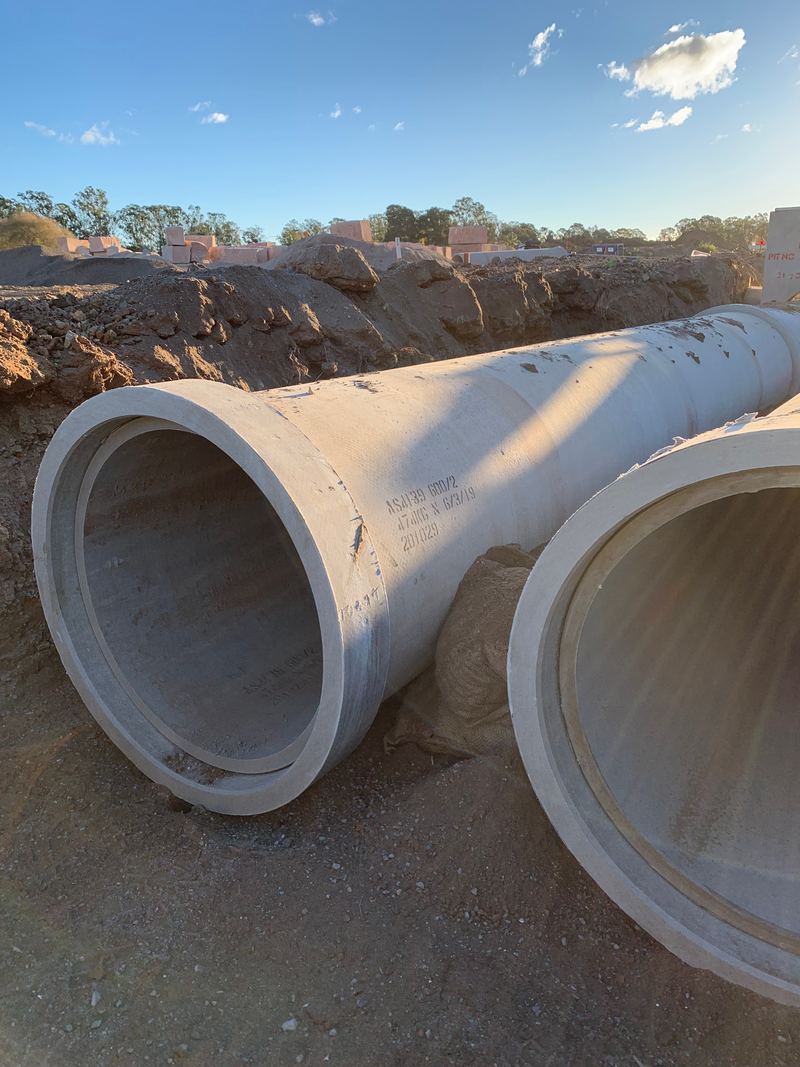 Large-diameter reinforced concrete stormwater pipes on site ready for laying